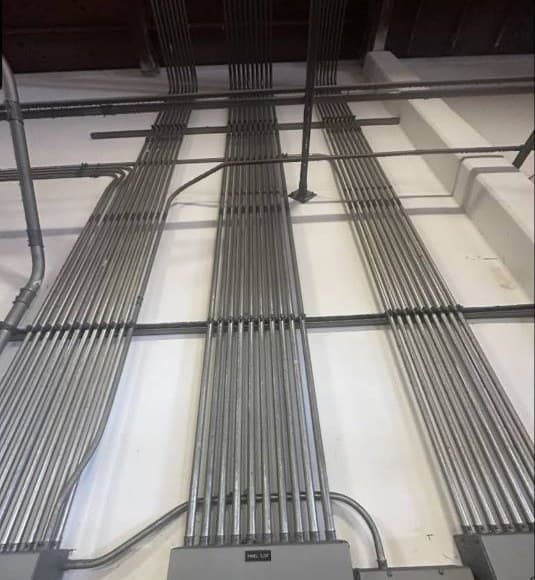 Commercial ceiling conduit runs installed in parallel lines by Foutz Electric.