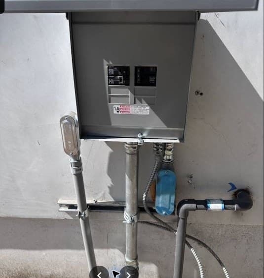 Exterior electrical service equipment with conduit and disconnects.