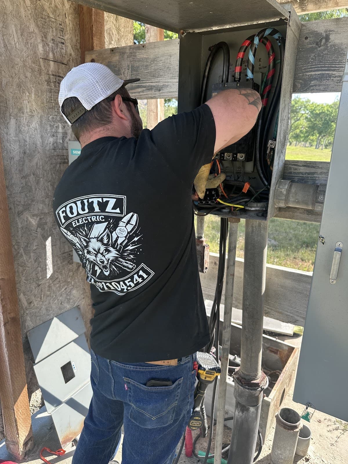 Foutz Electric worker servicing an electrical panel in the field.