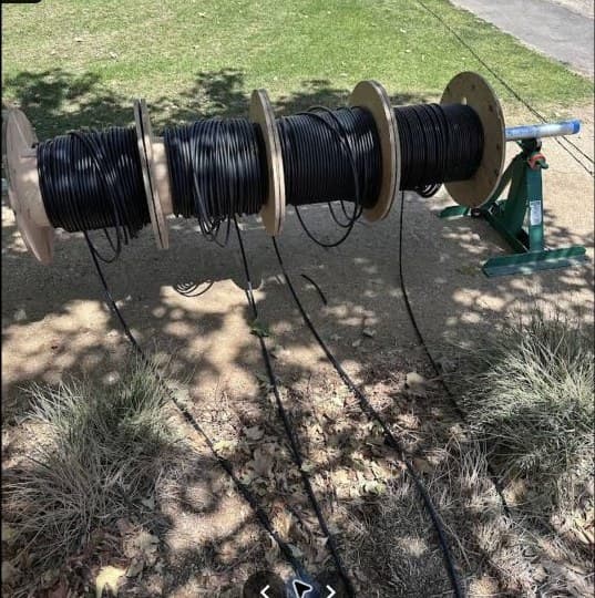 Cable spool staged for trenching and underground electrical work.
